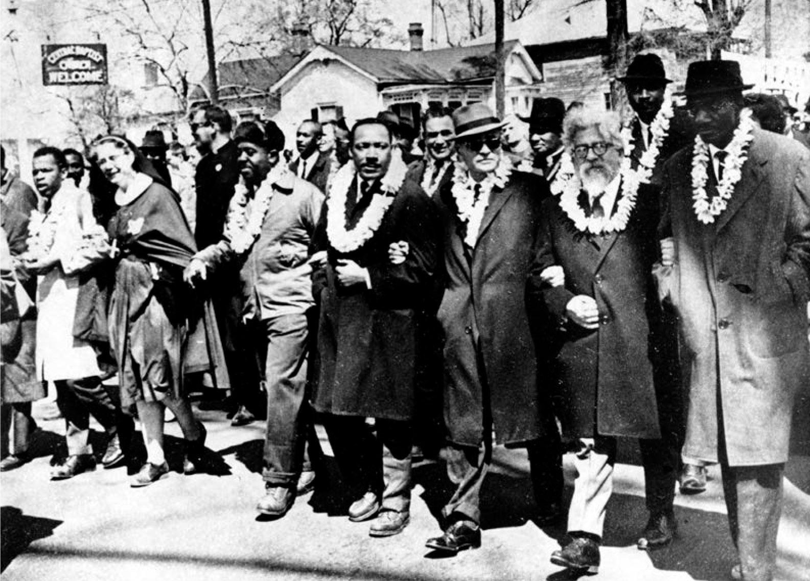 Rabbi Abraham Joshua Heschel, second from right, participating in the civil rights march from Selma to Montgomery, Alabama, on March 21, 1965. First row, from far left: John Lewis, an unidentified nun, Ralph Abernathy, Martin Luther King, Jr, Ralph Bunche, Abraham Joshua Heschel, Fred Shuttlesworth. Photo by the Associated Press, Public Domain via Wikimedia Commons