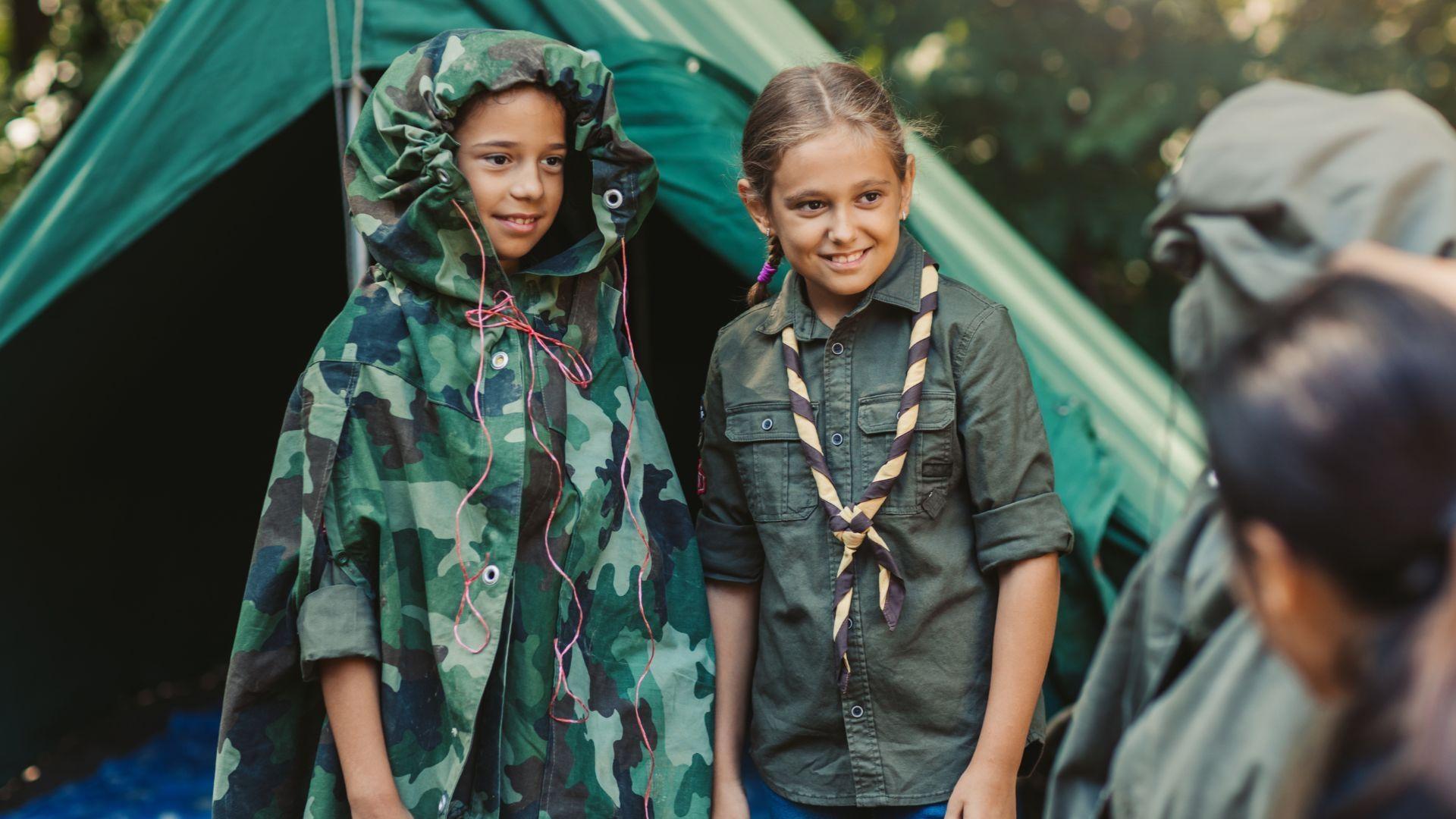 Two parents and their daughters gather around a laptop while sitting on a couch.