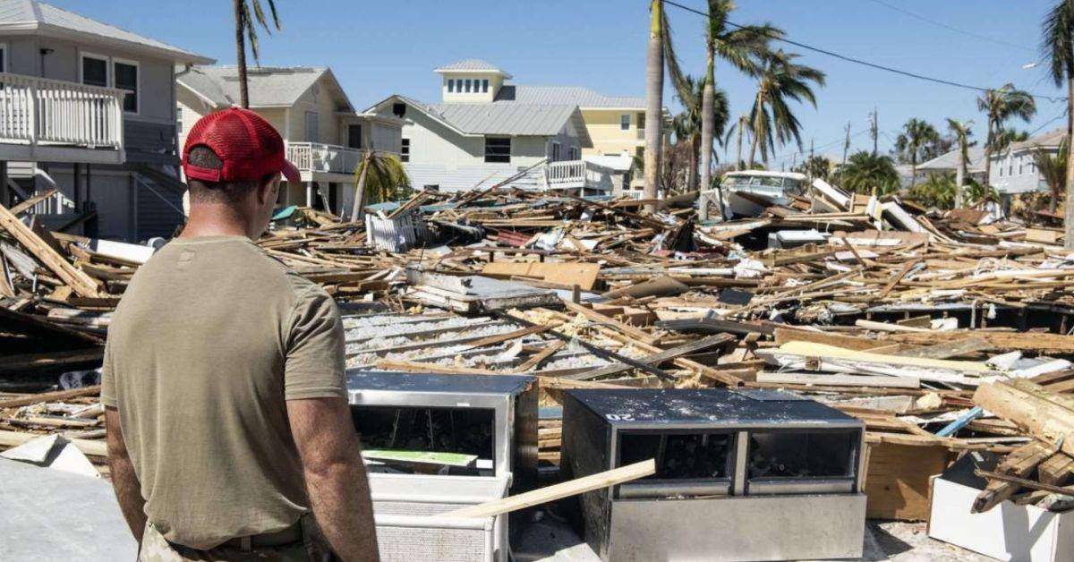 A man staring at the extreme damage caused by hurricane Ian in Florida.