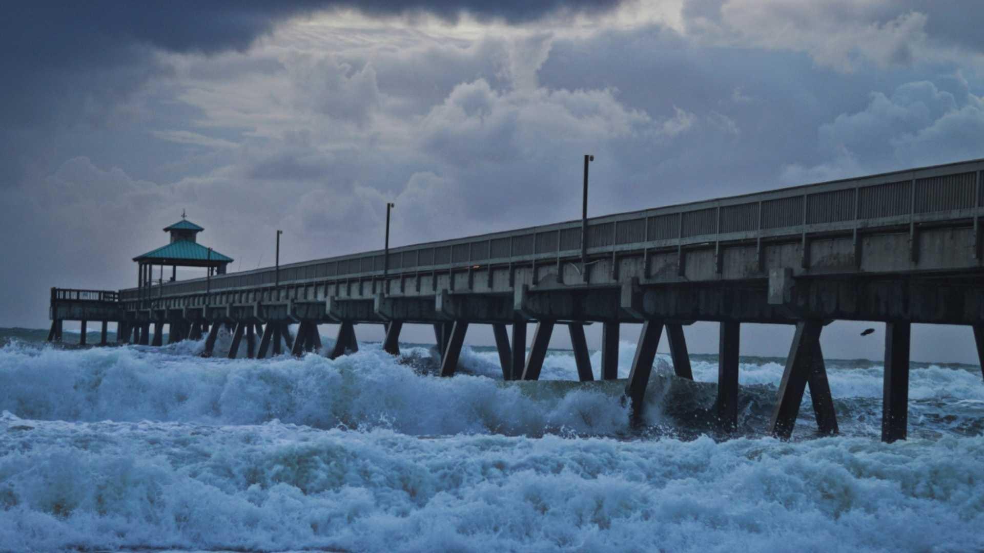 Strong waves and whitecaps under an ocean peer.