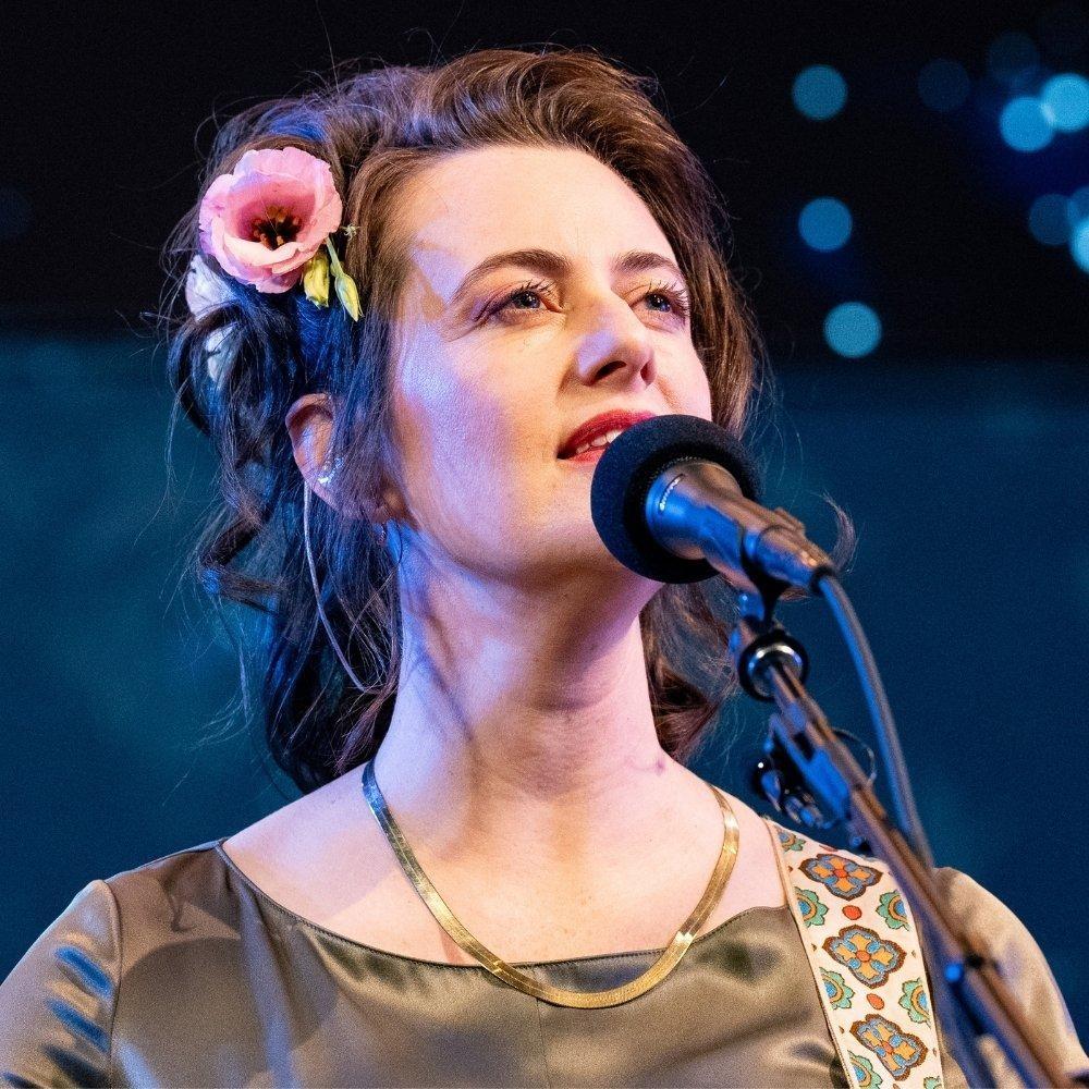 Skylar Gudasz singing into a microphone.