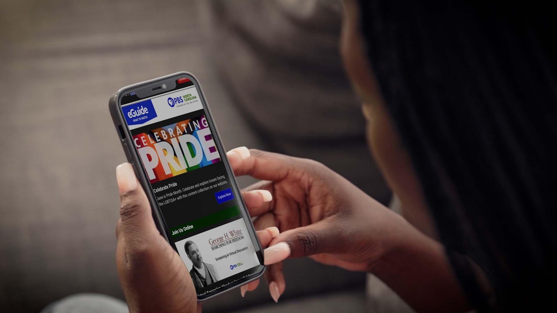 Hand holding a cellphone reading "Pride"